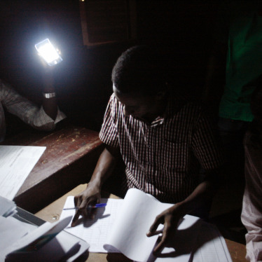 Election officials count votes by flashlight inside a school used as a polling station during elections in Niamey, Niger, Sunday, March 20, 2016.