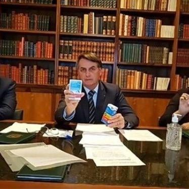 Brazil's President Jair Bolsonaro holds a drug he recommended to treat Covid-19 during a Facebook live event in April 2020. That drug has no proven effect against the virus.