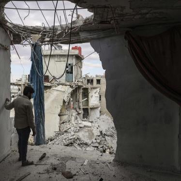 A man stands amongst rubble in an apartment building