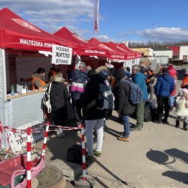 People lined up in front of red tents