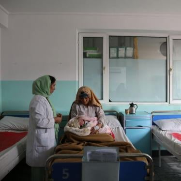 A woman in a hospital bed holds a newborn baby.