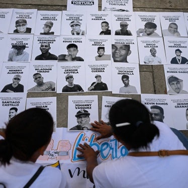 People posting photos of detainees on a wall