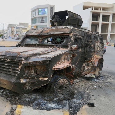 Boys walk past a damaged armored vehicle of an armed group after heavy clashes between militias rocked the capital and resulted in civilian casualties and destruction of homes, Tripoli, Libya, May 14, 2025.