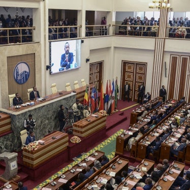 Ethiopia's Prime Minister Abiy Ahmed, center-left on the podium and on the video screens, addresses the parliament in Addis Ababa