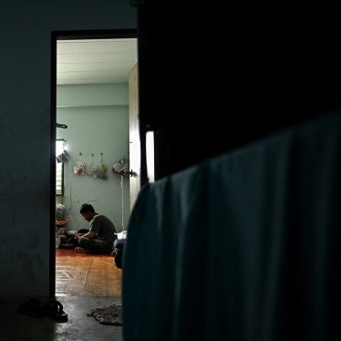 A man sits inside his apartment.