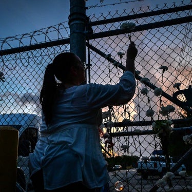 People place flowers on the fence of the Krome Detention Center during a vigil protesting US Immigration and Customs Enforcement custody and mass deportations in Miami, Florida, May 24, 2025.