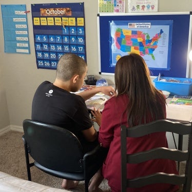 A mother supporting her 14-year-old son with autism in homeschooling, Orlando, Florida, US, October 1, 2020.
