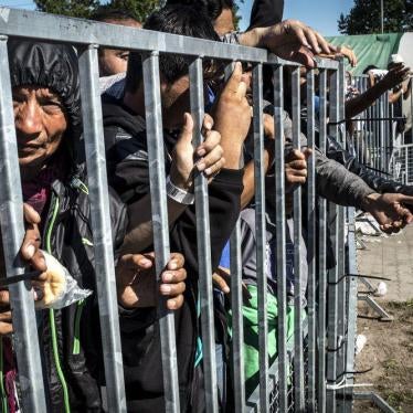 Asylum seekers behind a metal fence in the ‘Hangar 1’ detention center, in Röszke, Hungary.
