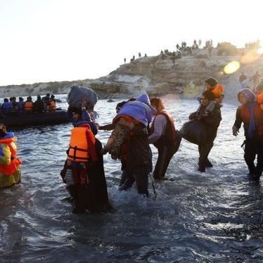 Refugees carrying their children walk towards a dinghy to sail off for the Greek island of Chios from Cesme, Turkey November 4, 2015. 