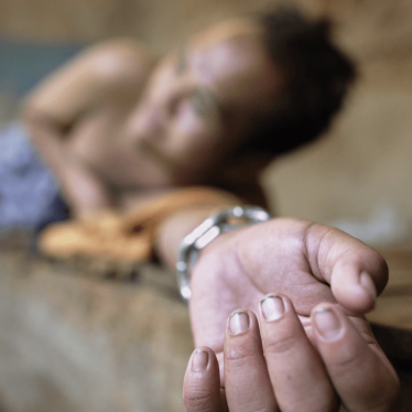 A man with psychological disability appears to be chained to a wooden bed.
