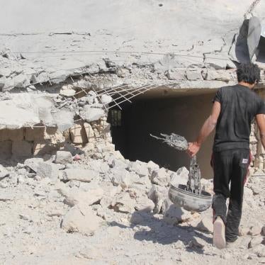 A man carries what appears to be a remnant of the parachute system of one of the bombs used in the attack on a school complex in al-Hass on October 26.