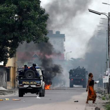 Congolese police drive past a fire barricade during demonstrations in Kinshasa, the capital of the Democratic Republic of Congo, December 20, 2016.