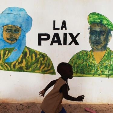 A boy in Timbuktu runs in front of a mural that reads “Peace,” a few days before the July 2013 presidential elections in Mali.