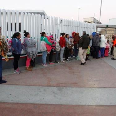 Immigrants from Central America and Mexican citizens, who are fleeing from violence and poverty, queue to cross into the U.S. to apply for asylum.