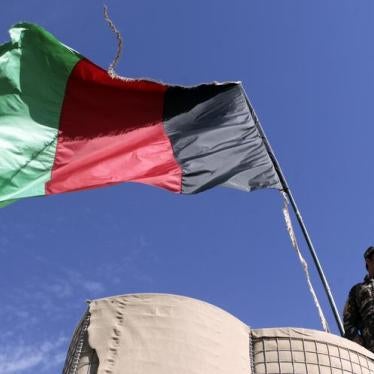 An Afghan National Directorate of Security (NDS) police stands guard next to an Afghanistan flag at a guard post of a police camp in Now Zad district in Helmand province, southwestern Afghanistan November 6, 2012.