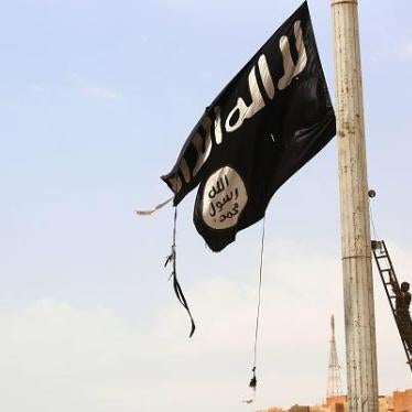 A member of the Syrian Democratic Forces removes an Islamic State flag in the town of Tabqa, west of Raqqa city, Syria, April 30, 2017. © 2017 Getty Images