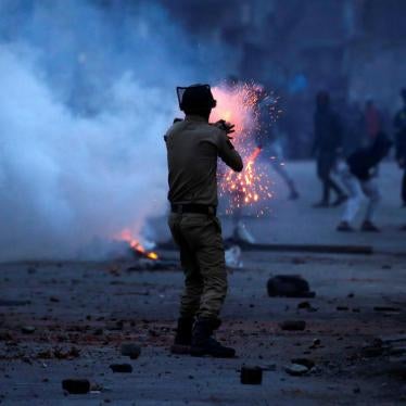 An Indian police officer fires a tear gas shell toward demonstrators, during a protest against the recent killings in Kashmir, in Srinagar, May 8, 2018.