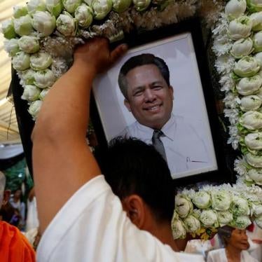 A man holds portrait of Kem Ley, an anti-government figure and the head of a grassroots advocacy group, "Khmer for Khmer", shot dead on July 10, as they attend a funeral procession to carry his body to his hometown, in Phnom Penh July 24, 2016.