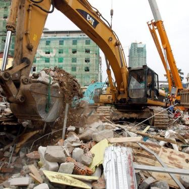 An excavator removes the rubble at the site of a collapsed building in Preah Sihanouk province, Cambodia, Saturday, June 22, 2019.