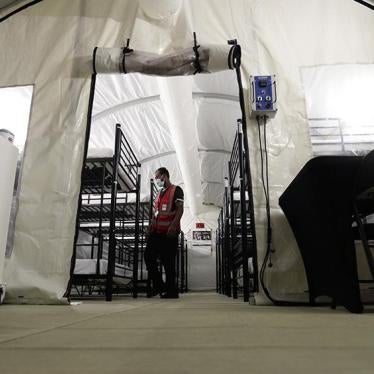 A staff member works in the infirmary, a series of tents, at a US government immigration holding center in Carrizo Springs, Texas