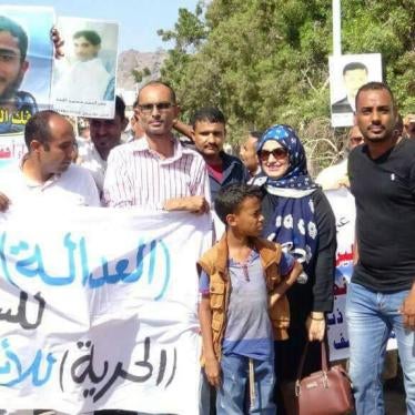 Demonstrators hold up pictures of detainees and a sign demanding "Justice for the prisoners and justice for the innocent" during a 2017 demonstration in Aden, Yemen. 